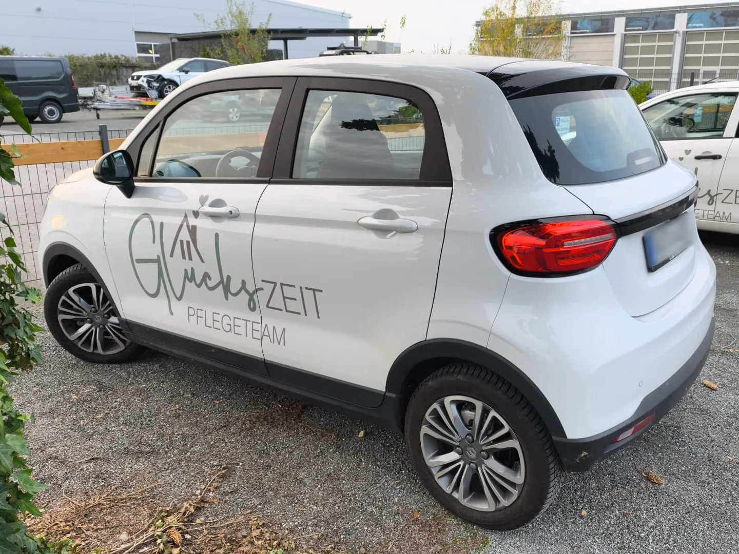 Weißer Leapmotor T03 mit dem Schriftzug Glückszeit Pflegeteam, schräg von hinten